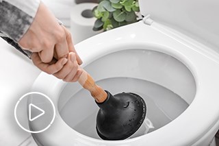 Image of person using plunger to unblock toilet